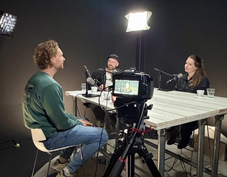 Podcast opnemen in Haarlem met professionele studio, camera en microfoons – gesprek tussen meerdere sprekers aan tafel in podcast studio