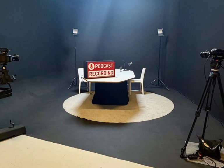 Studio huren voor podcast opnemen met professionele camera’s, verlichting en podcast tafel – voorbeeld van ingerichte podcast studio